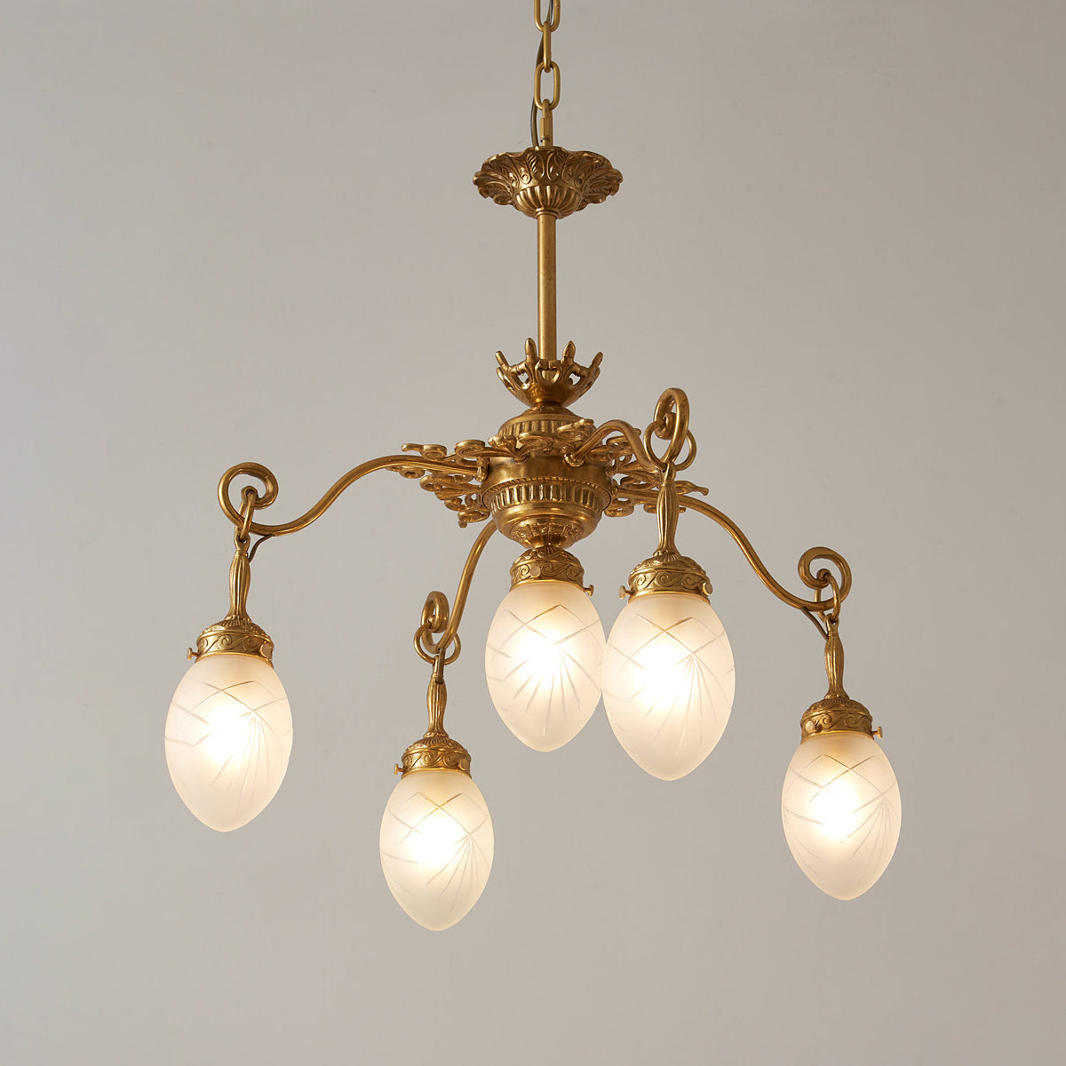 Close-up on the connection point of the brass arm and glass shade.