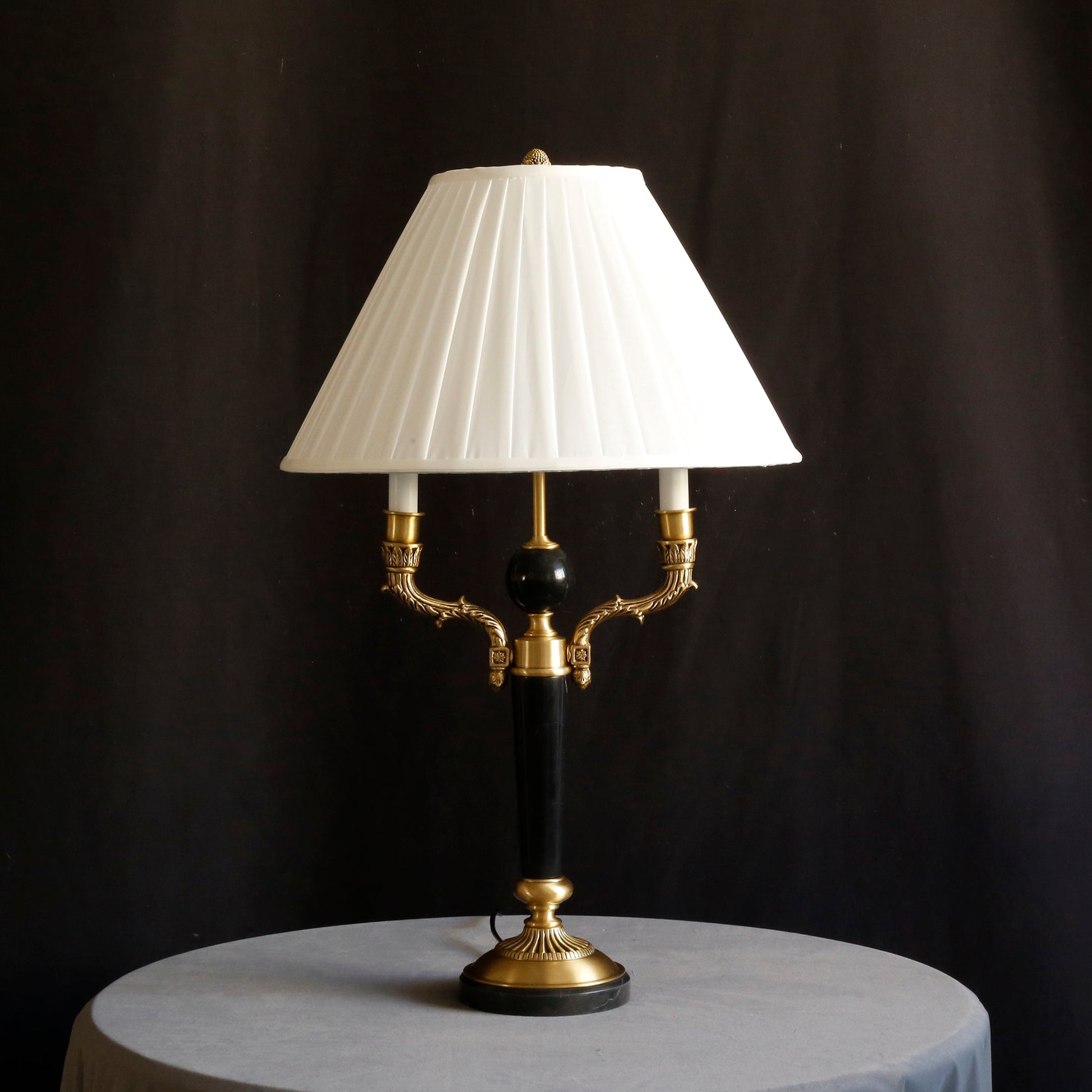 Texture detail of the pleated fabric on the lamp's white shade.