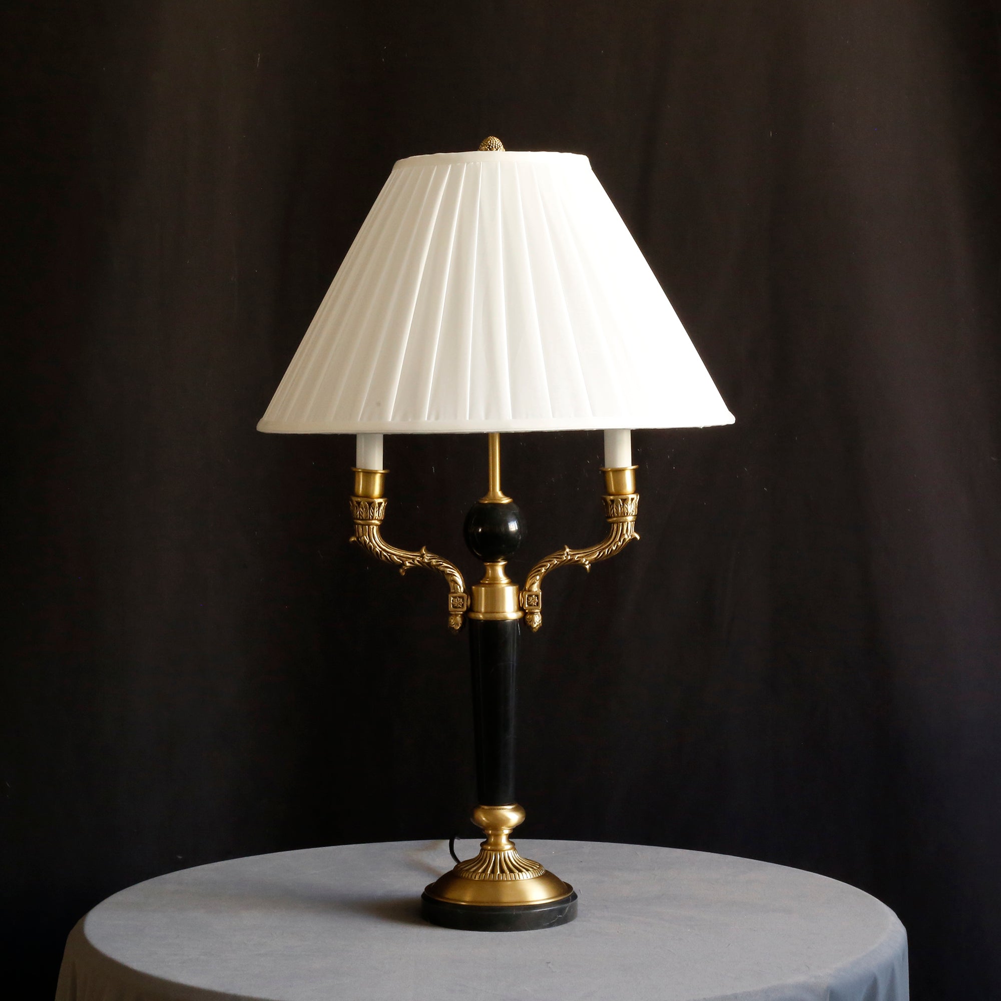 Texture detail of the pleated fabric on the lamp's white shade.