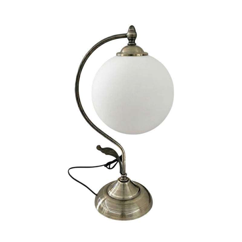 Lifestyle image of the Evelyn Glass Table Lamp on a side table in a modern living room.