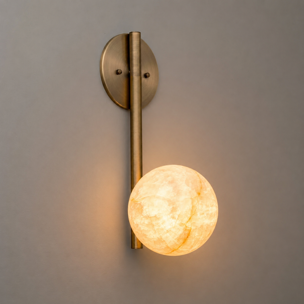 The Adrion sconce shown against a dark, textured wall for contrast.