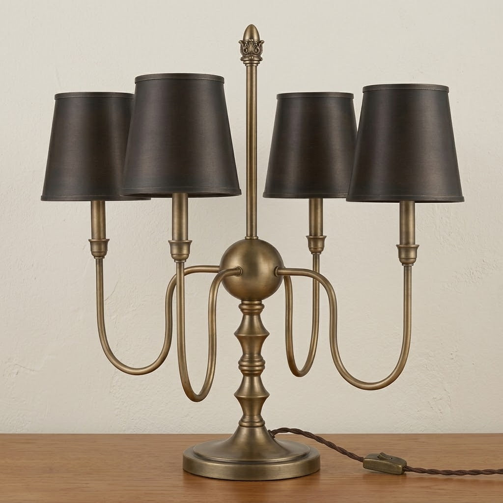 Close-up of the Alden Table Lamp's sculpted brass base and sweeping arms.