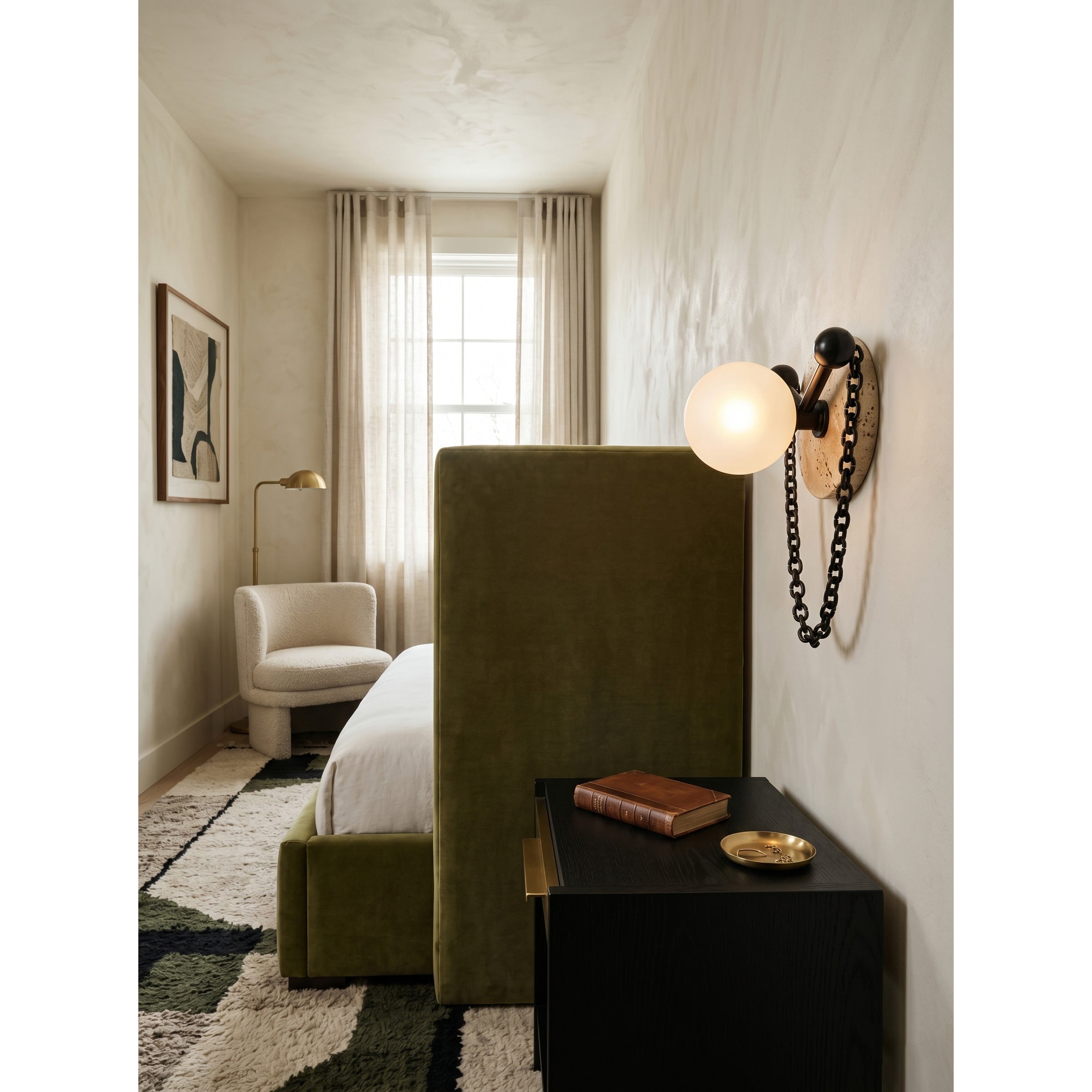 Alla Wall Sconce installed above a bedroom headboard.