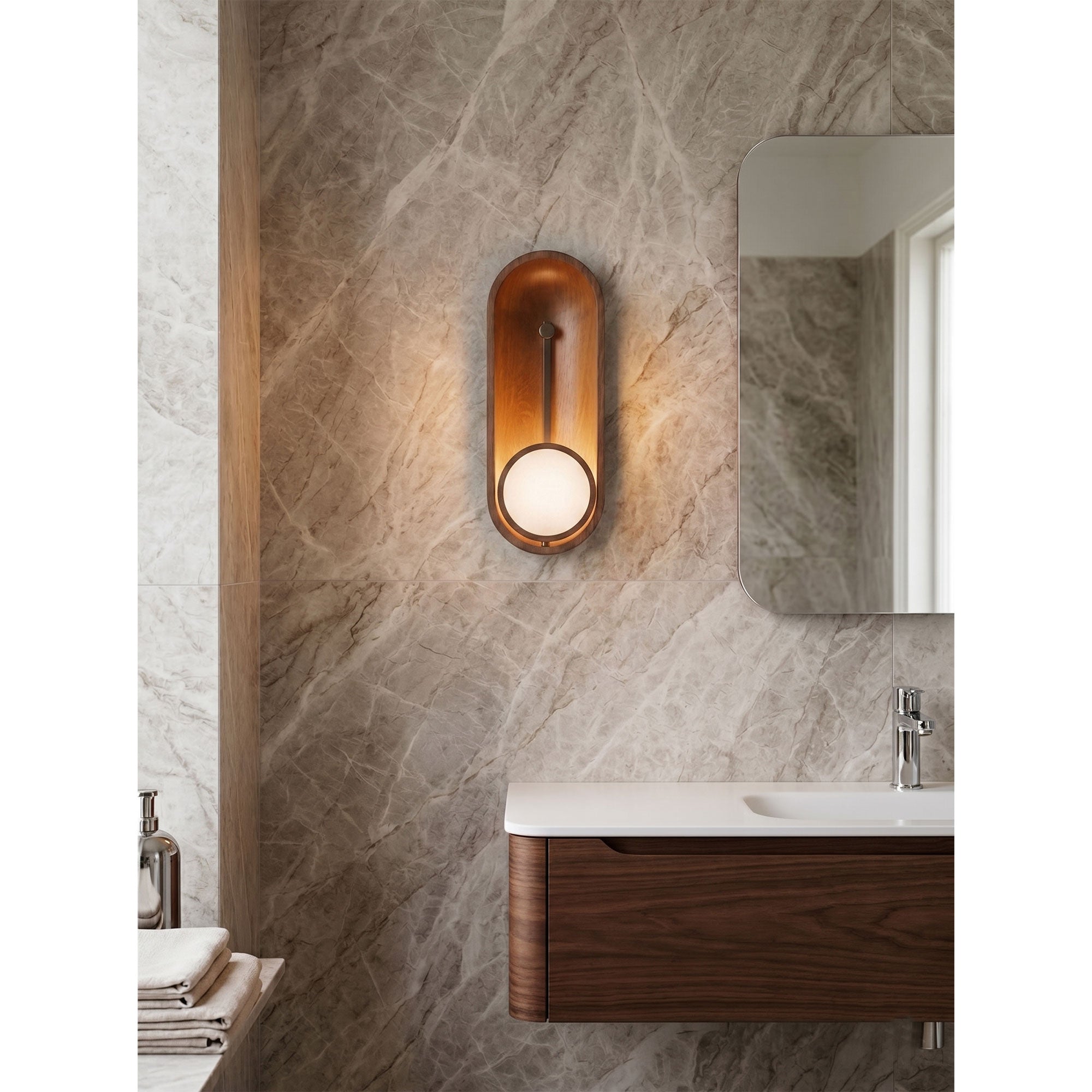 Lifestyle view of the Aperture Wall Sconce installed in a modern bathroom next to a mirror.