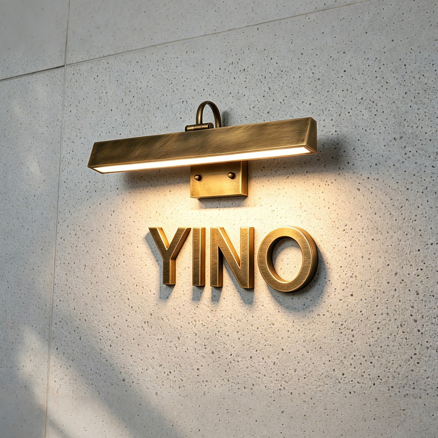 Arti Brass Wall Sconce against a dark wall.