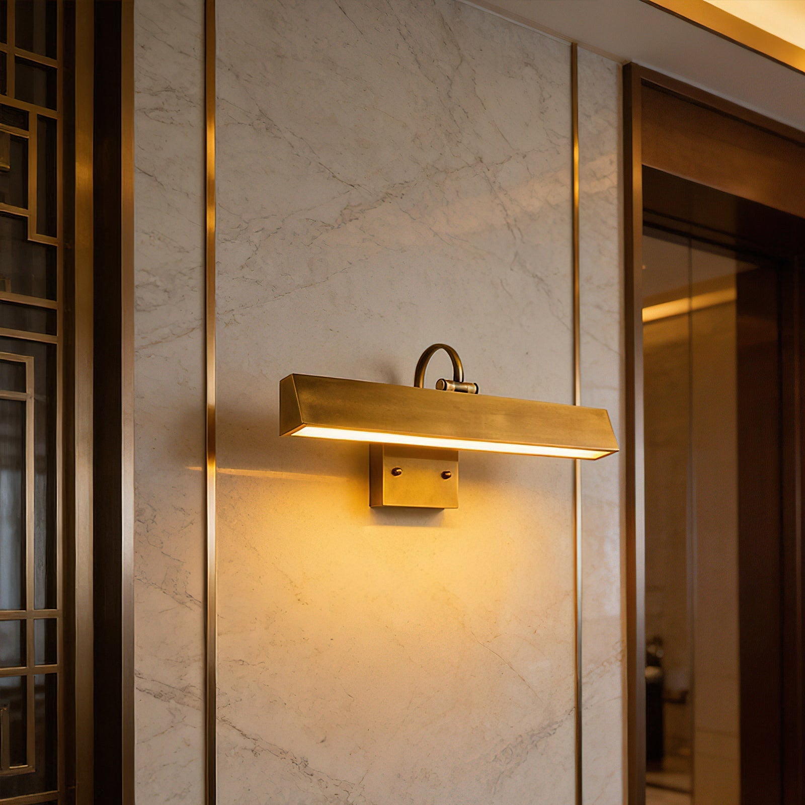 The Arti Wall Sconce illuminating a piece of art in a dimly lit room.