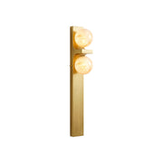 Asymmetrical alabaster wall sconce with brass frame against a neutral wall.