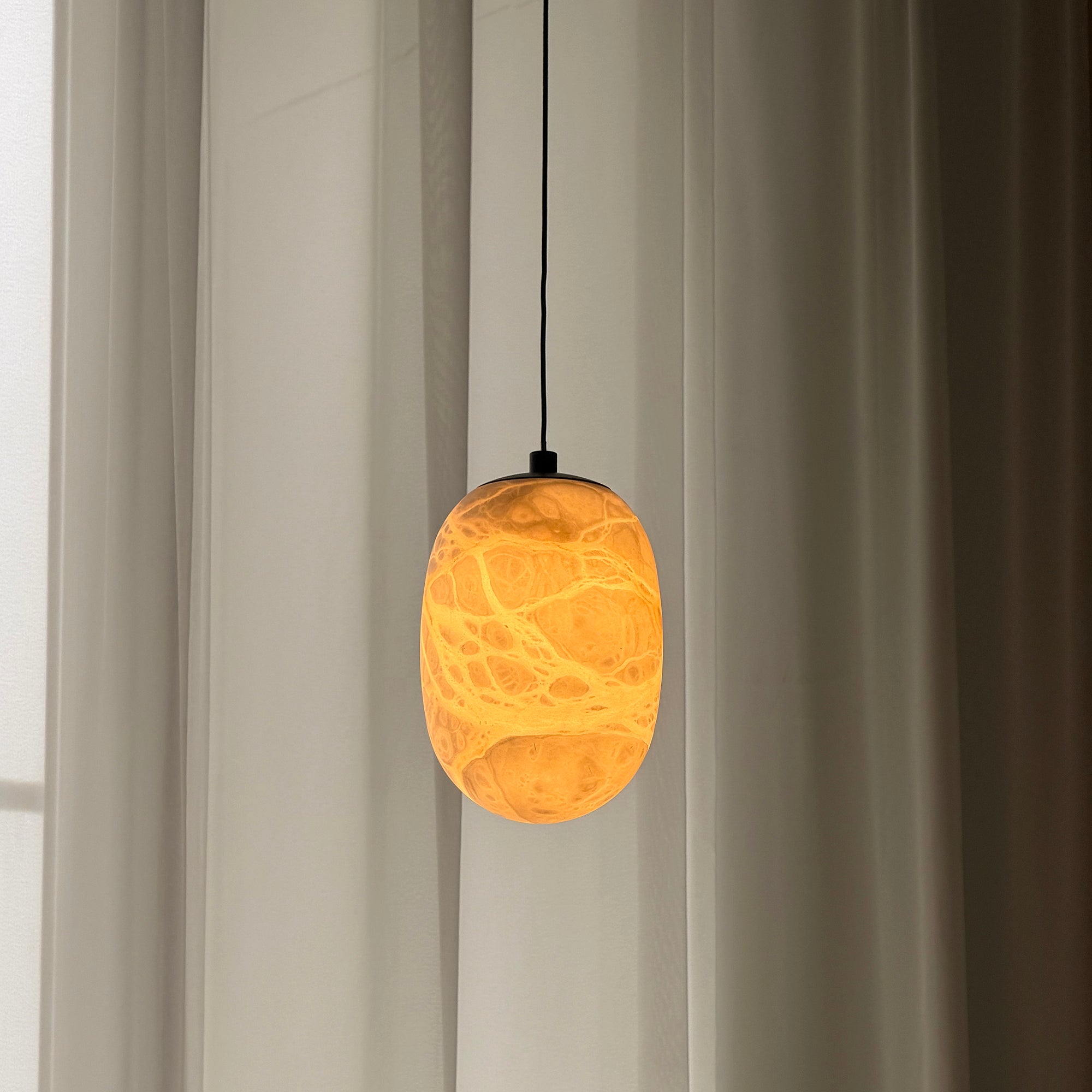 The lamp unlit, highlighting its sculptural form.