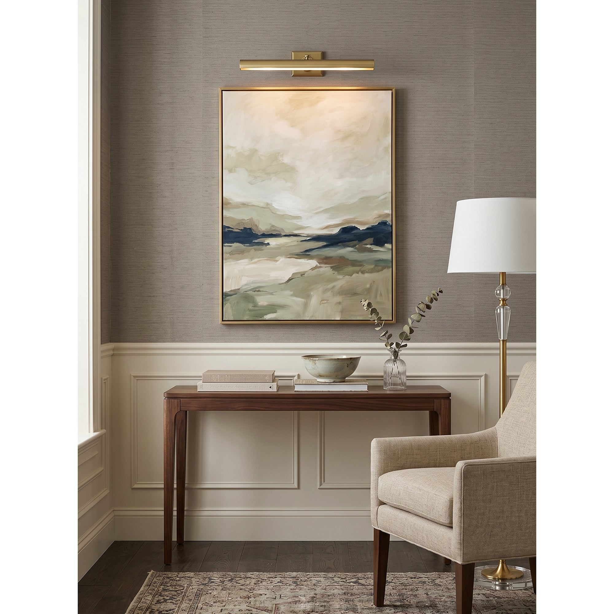 The Bilbury wall sconce installed over a painting in a gallery setting.