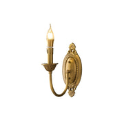 Blair Candle Wall Sconce in antique brass finish against a dark wall.