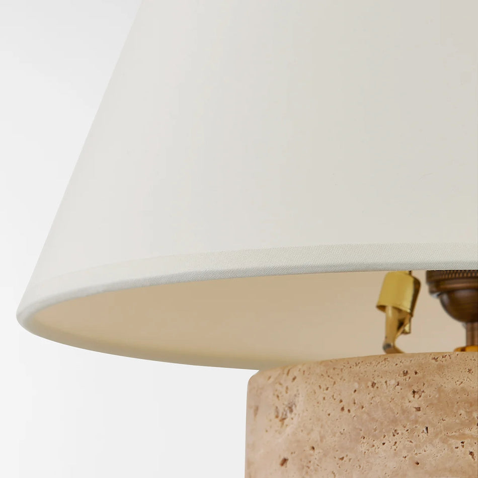 The squat cylindrical travertine base from a low angle.