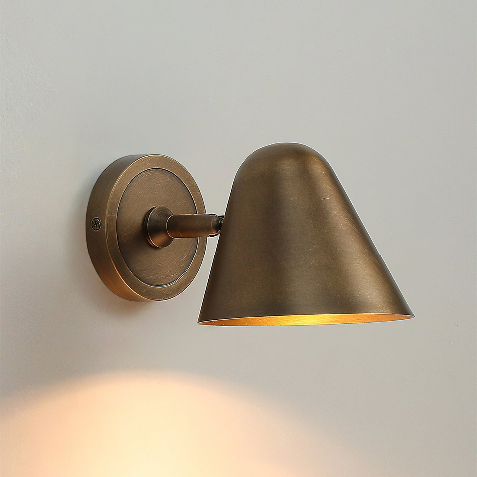 The brass sconce complementing a mid-century modern decor.