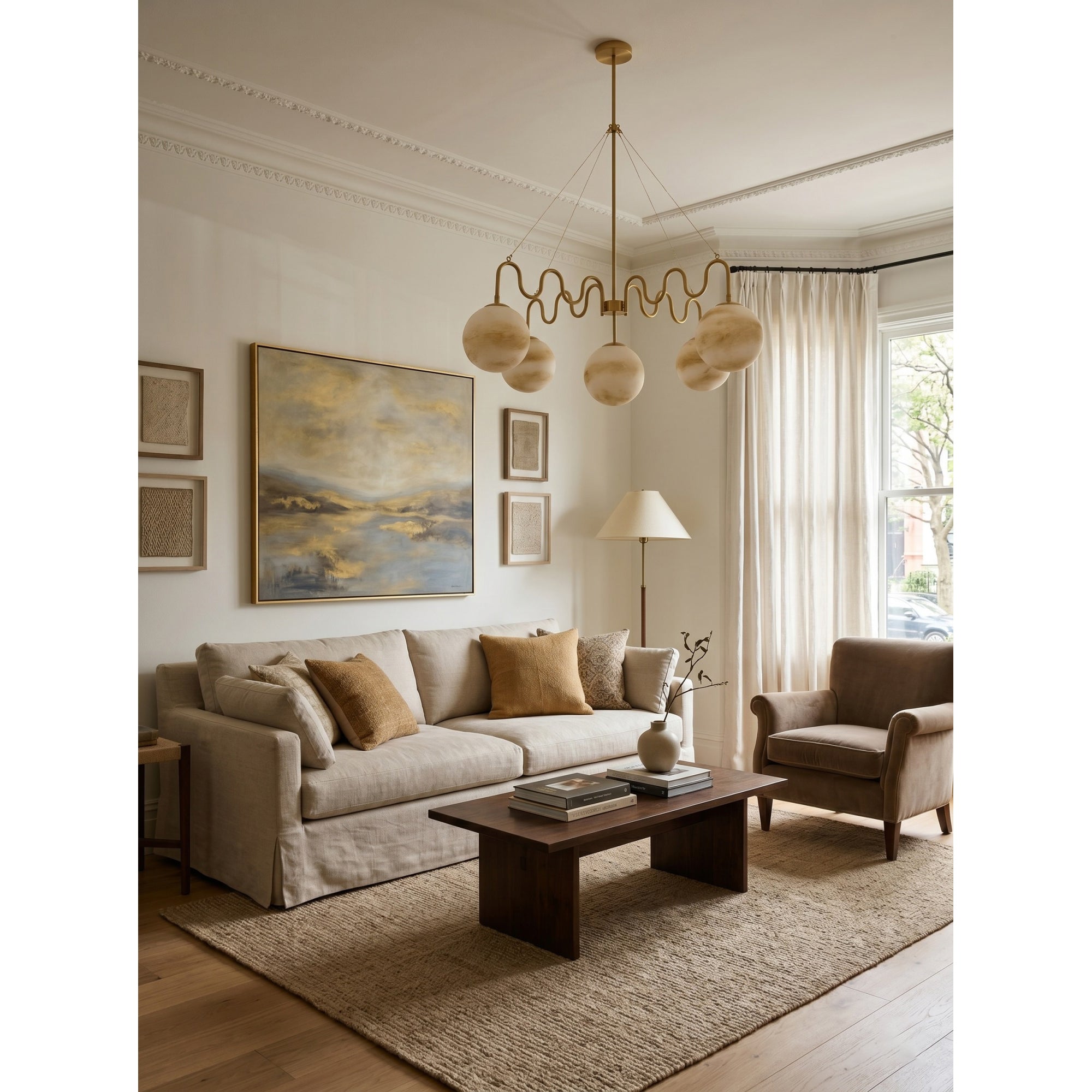 Lifestyle image of the brass Cecil Chandelier in a high-ceiling entryway.