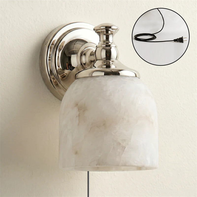 The warm, diffused glow from the alabaster shade when the sconce is lit.