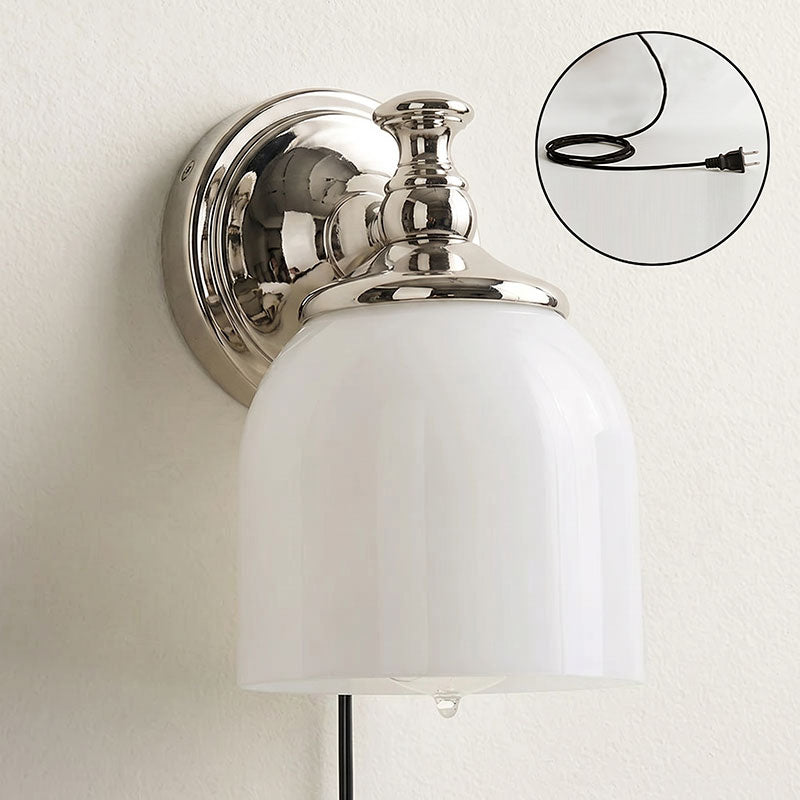 The 1-head brass sconce mounted on a light-colored wall.
