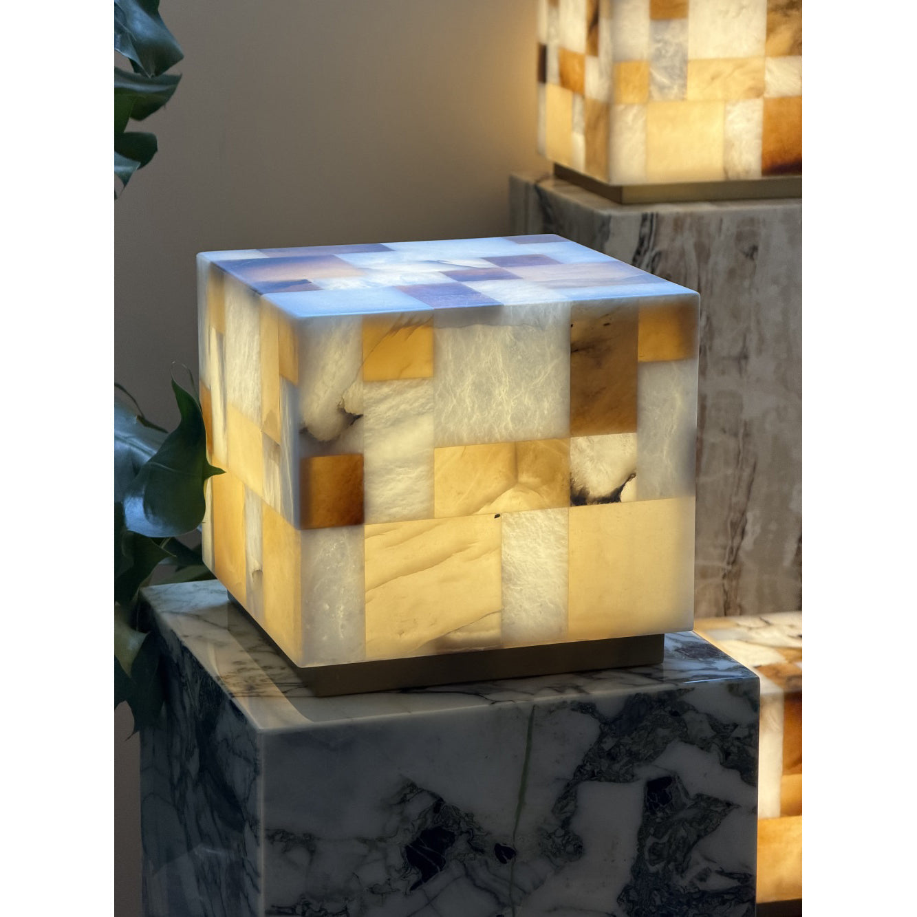 The lamp on a wooden side table next to a book.