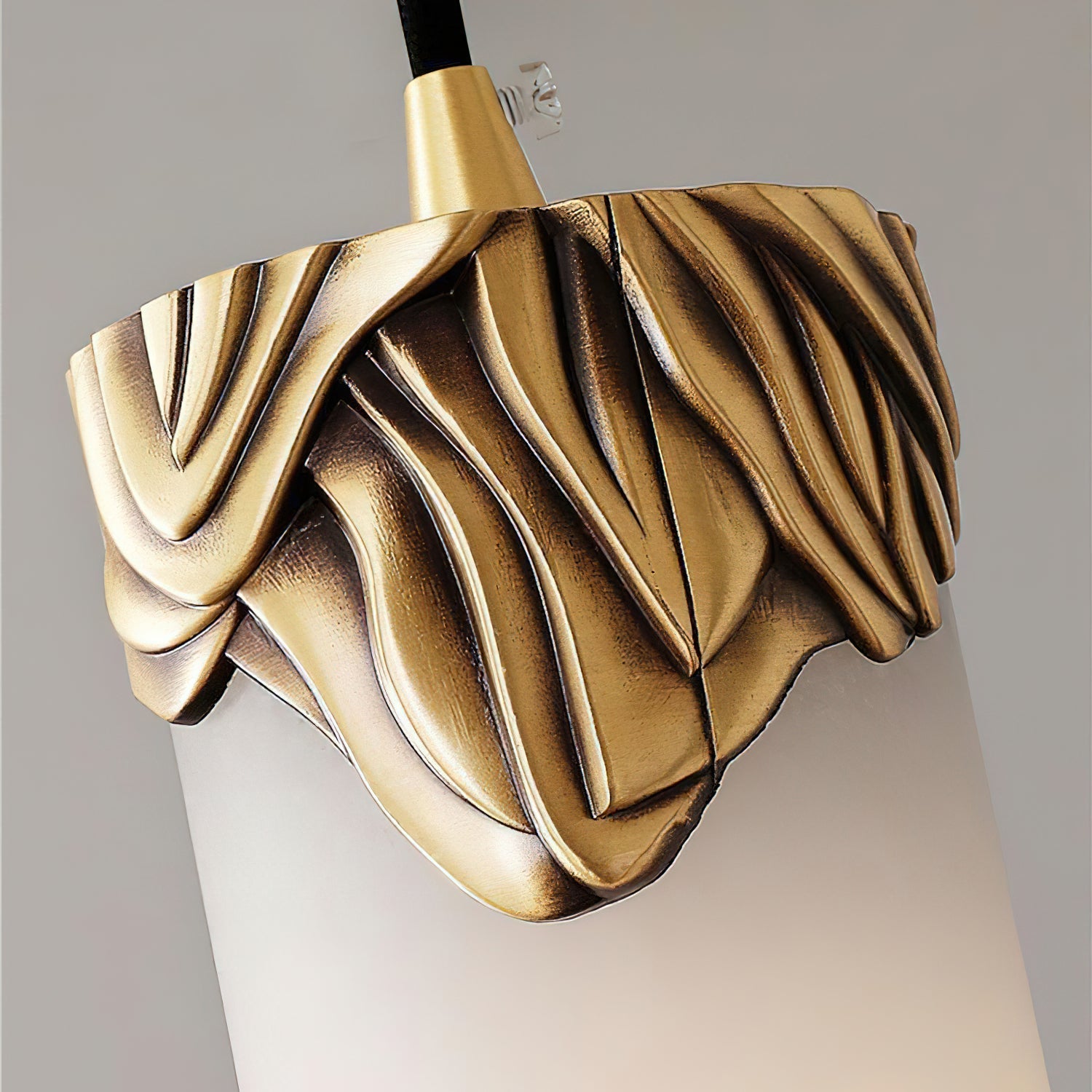 Ornate gold leaf-style metalwork detail on the top of a pendant.