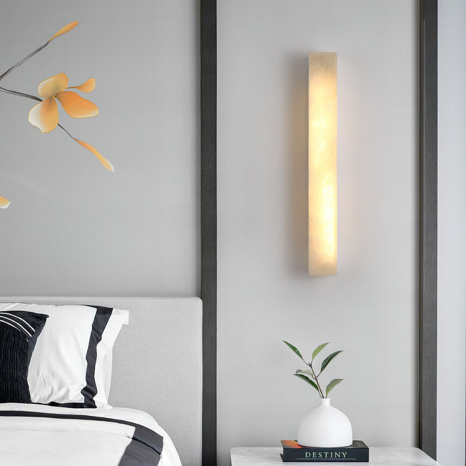 Dara alabaster wall sconce illuminating a dark hallway.
