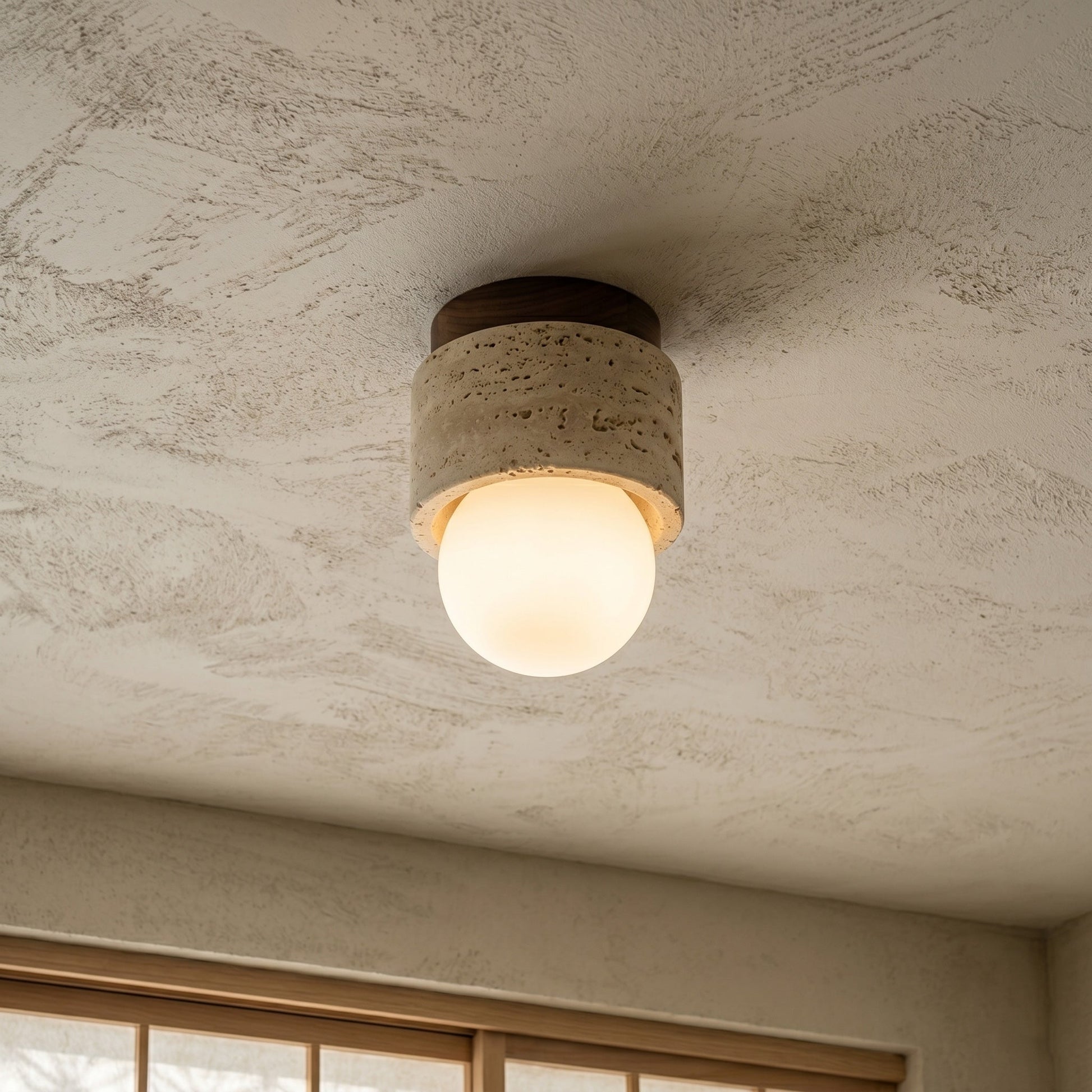 Close-up of the natural travertine stone texture on the Davise Flush Mount.