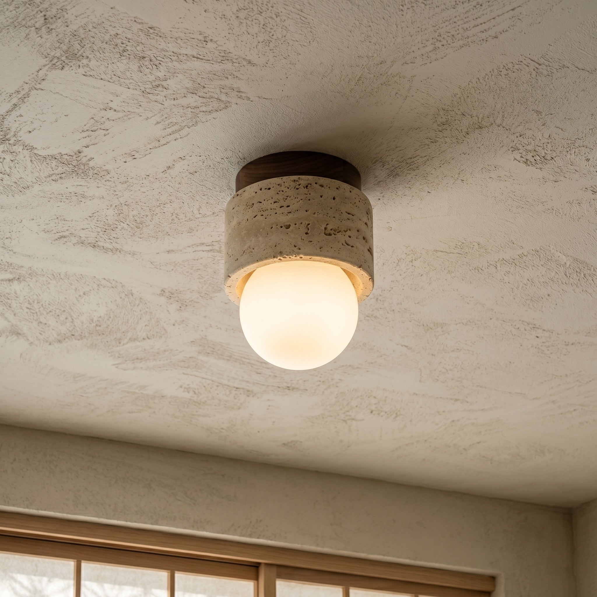 Close-up of the natural travertine stone texture on the Davise Flush Mount.
