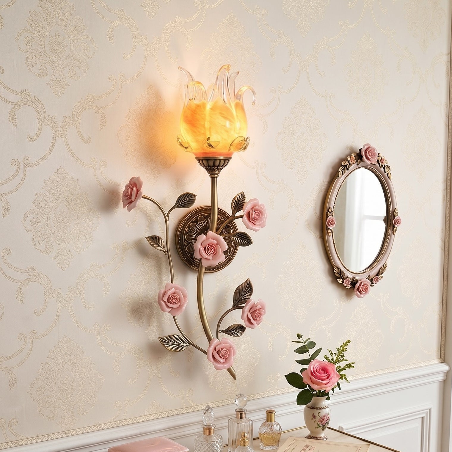 Close-up view of the pink ceramic roses and antique bronze leaves on the sconce.