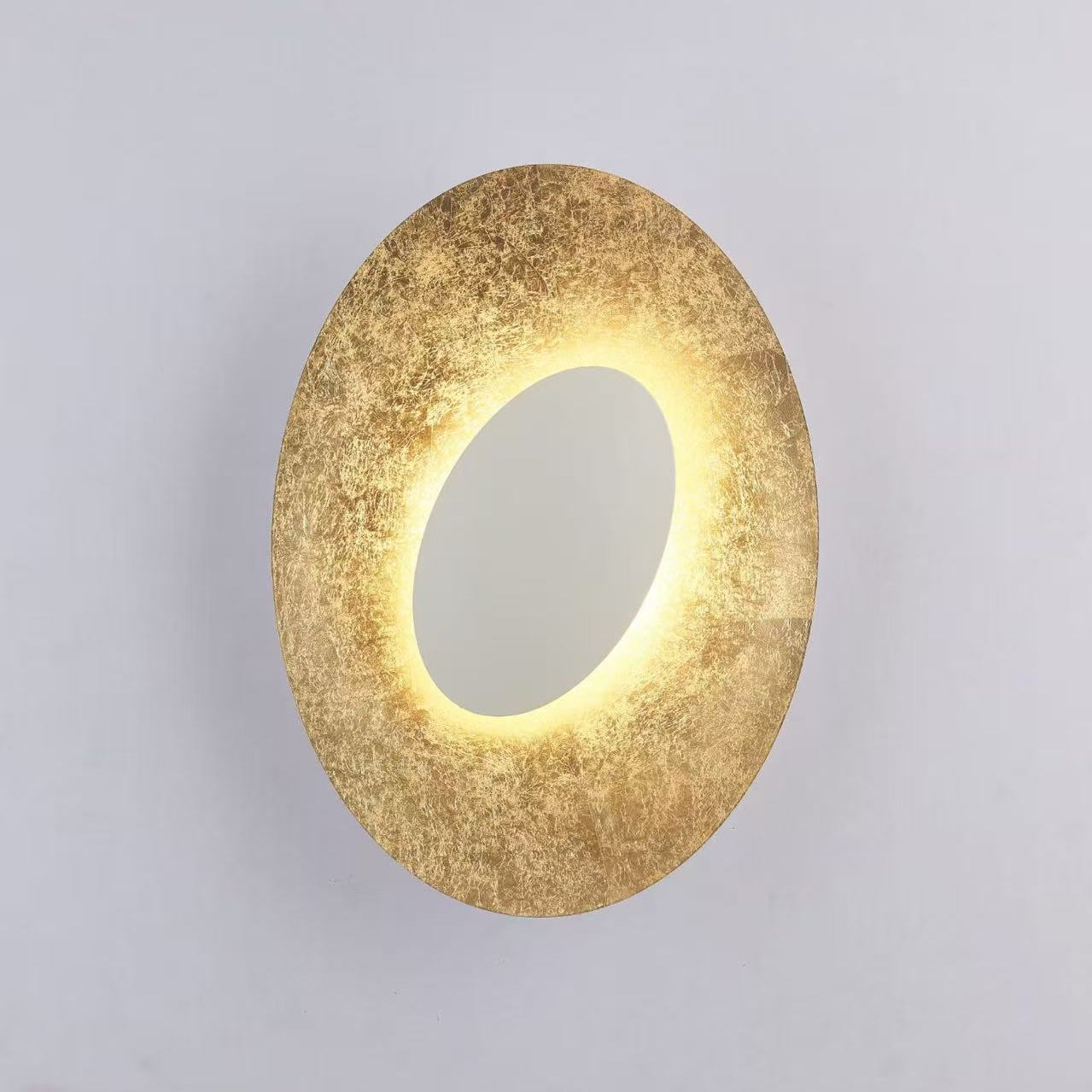 Close-up shot detailing the hand-applied gold leaf texture on the Escale Blade Wall Sconce.