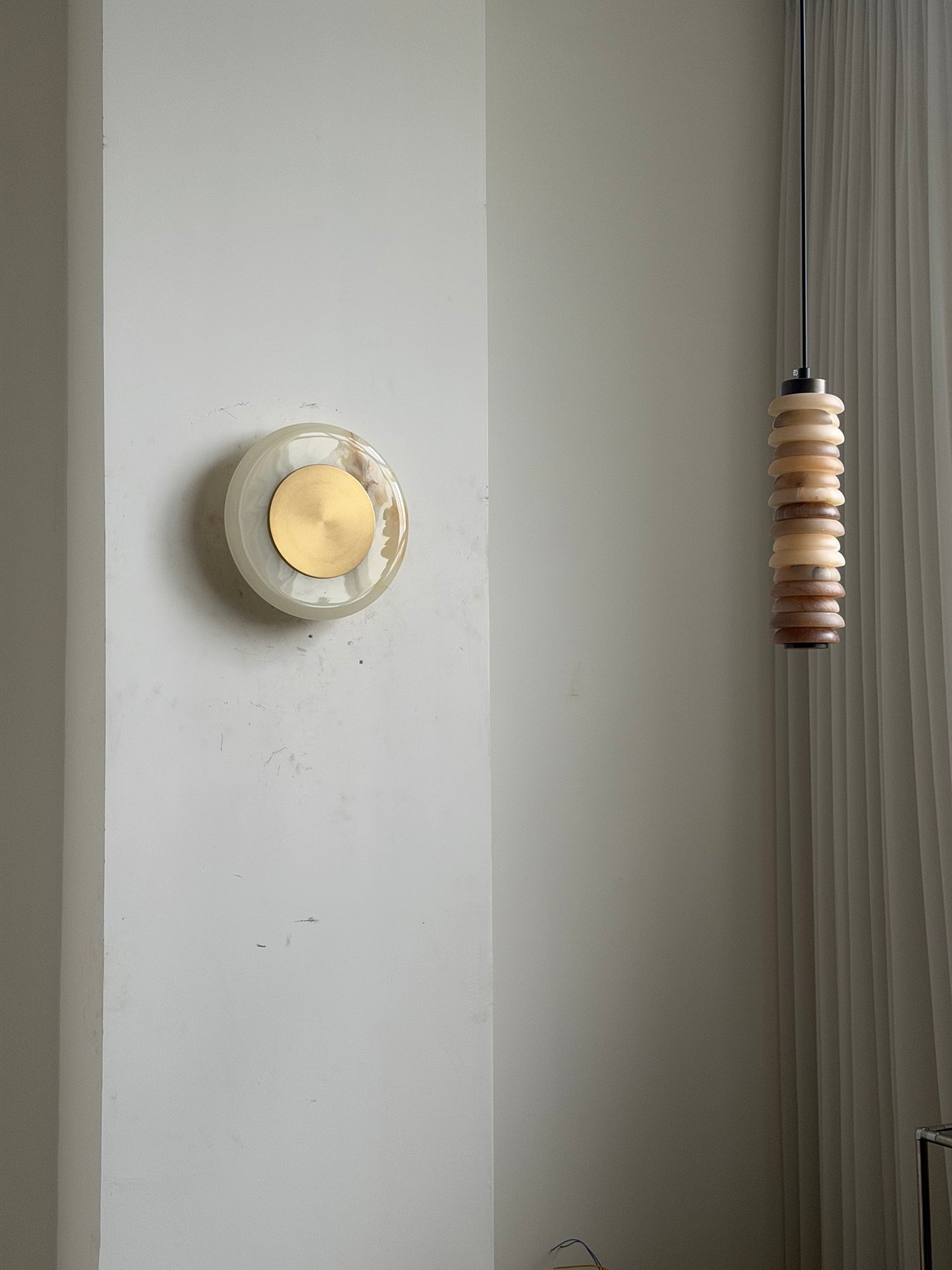 The Cyan Onyx sconce shown unlit against a light wall.