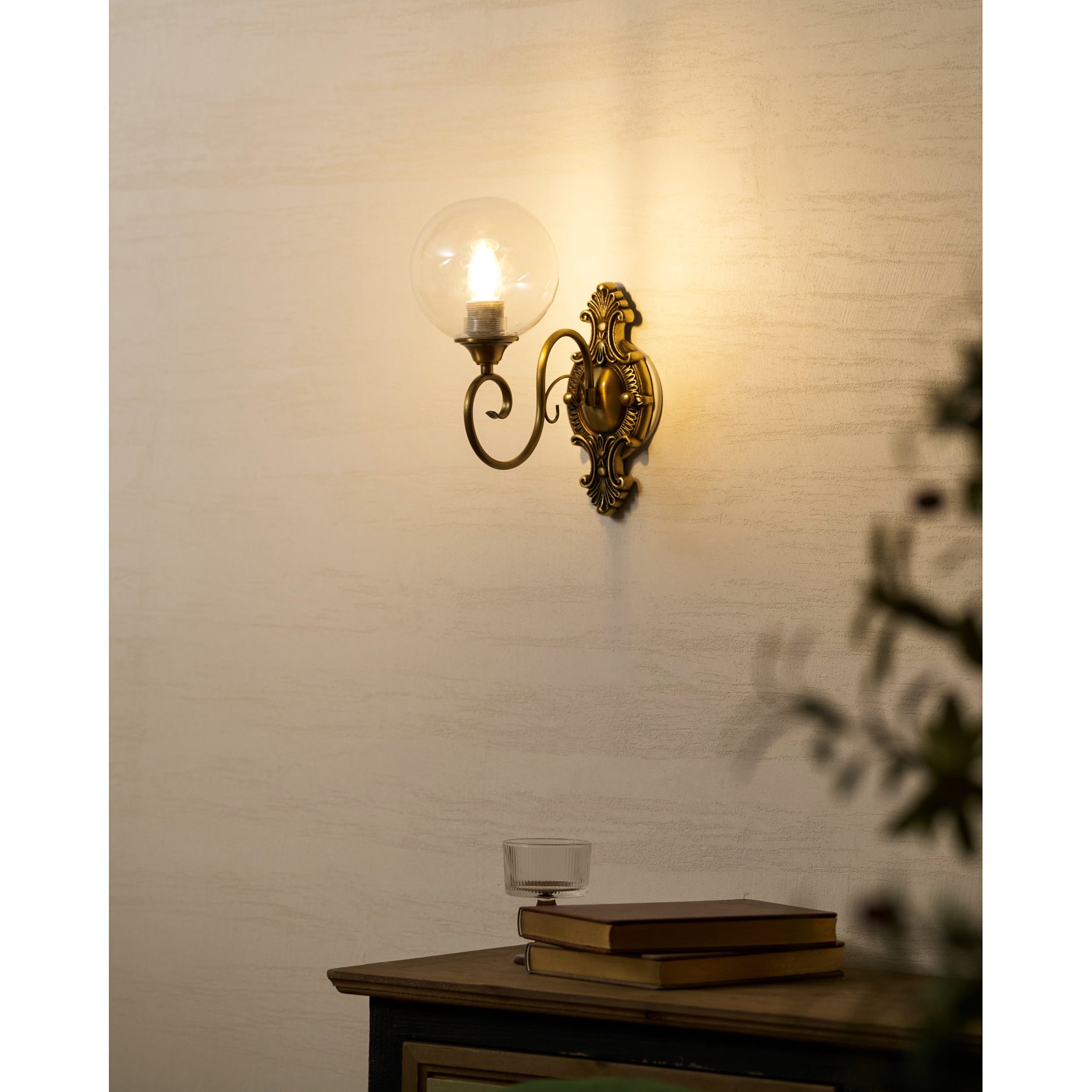 The Evelyn Wall Lamp in white finish, illuminated against a dark wall.