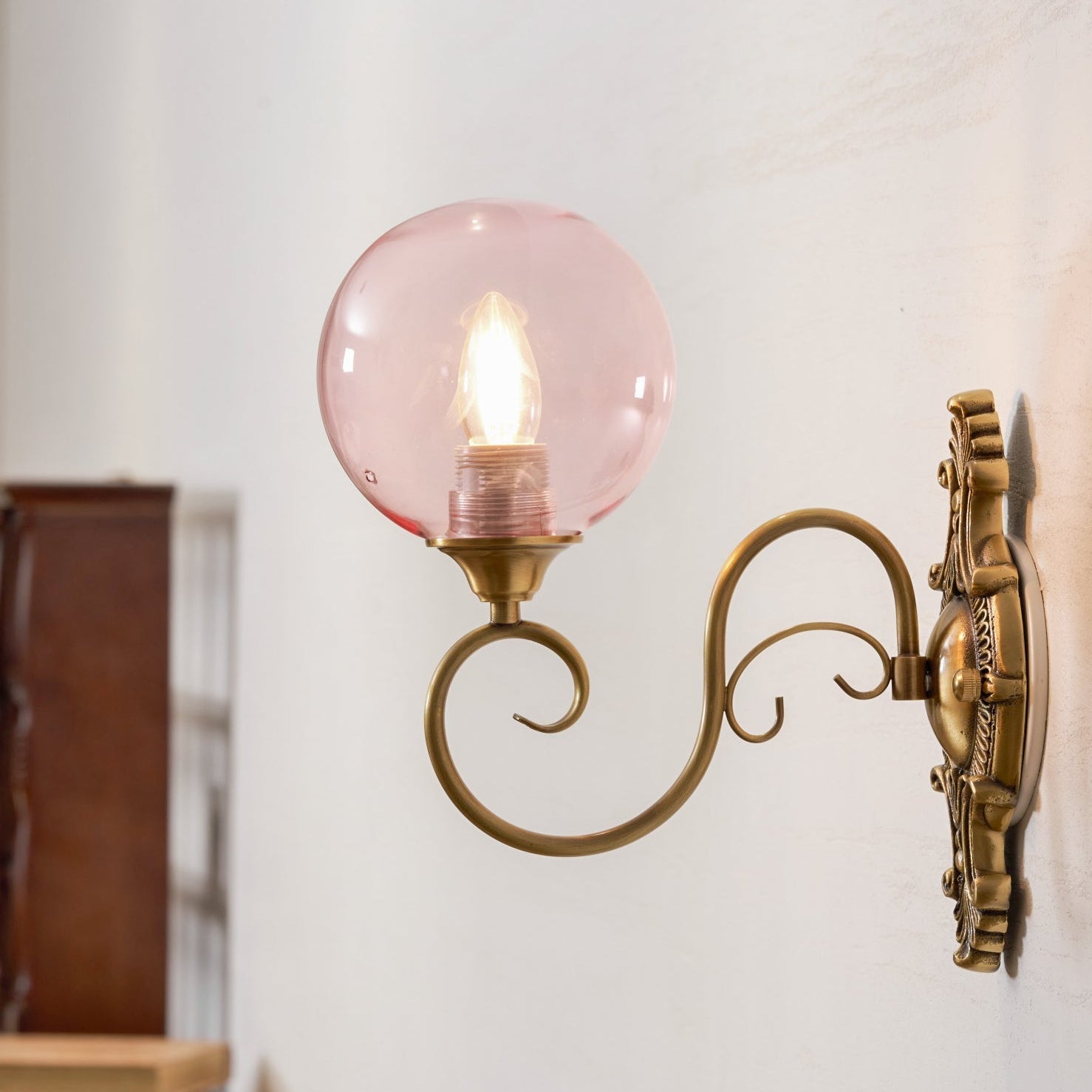 Side view of the Evelyn Glass Wall Lamp showcasing its scrolled ironwork.