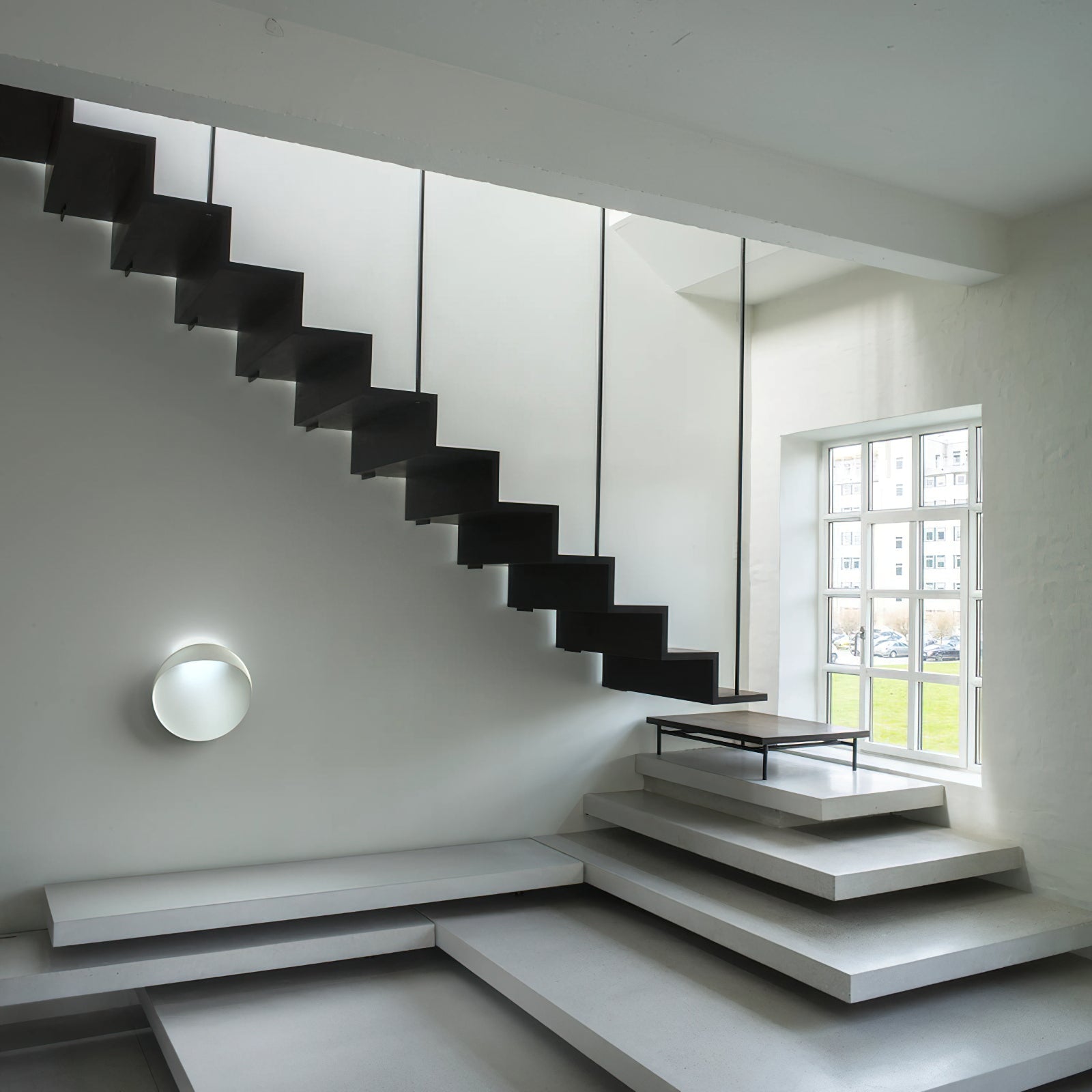 The circular silhouette of the Flindt sconce, unlit.