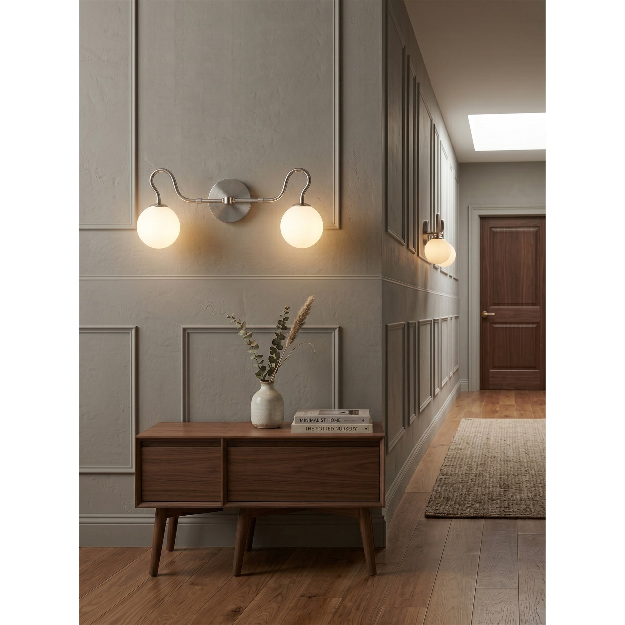 Angled view of the Floren Double Wall Sconce in brass against a dark wall.