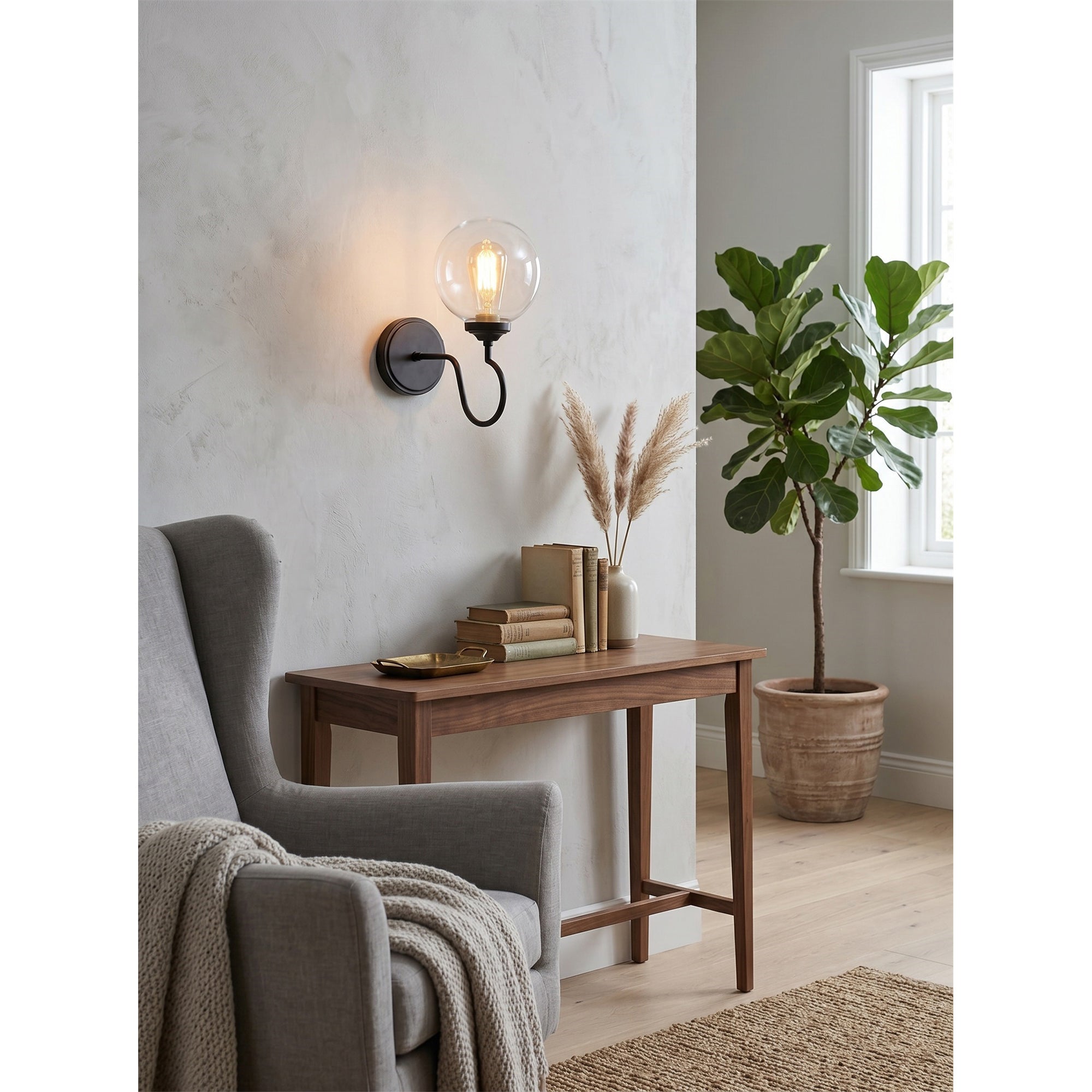 Floren Wall Sconce with a clear glass globe, showing the bulb inside.