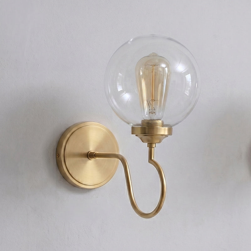 Floren Wall Sconce in brass finish against a dark, textured wall.