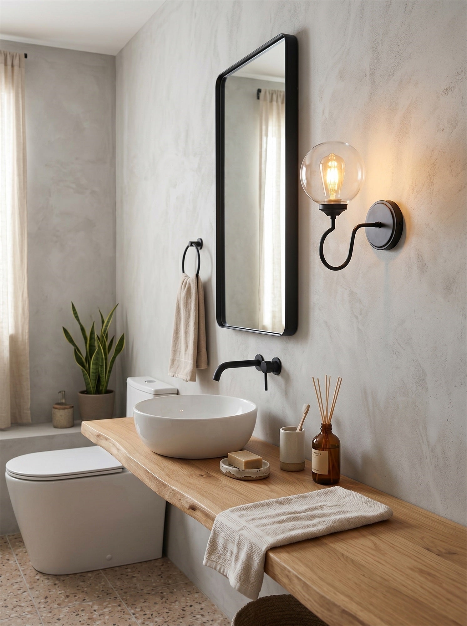 Angled view of the Floren Wall Sconce in brass, highlighting its curved arm.