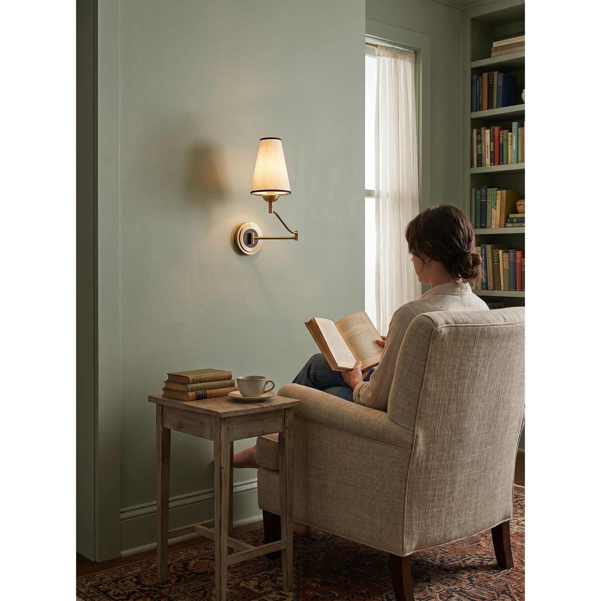 The wall sconce against a dark wall, highlighting the warm brass finish.