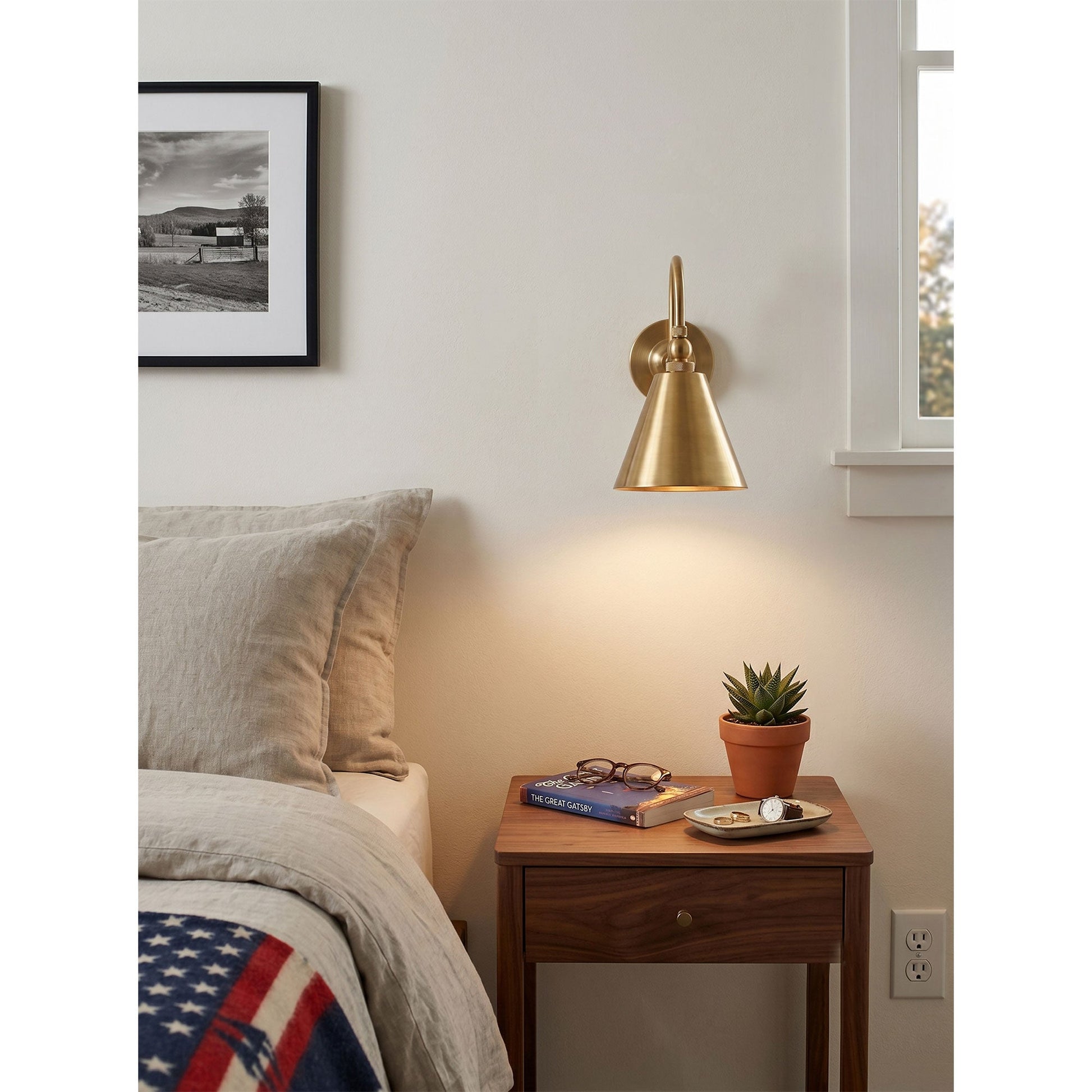 The Forna Brass Wall Sconce illuminating a comfortable reading nook.
