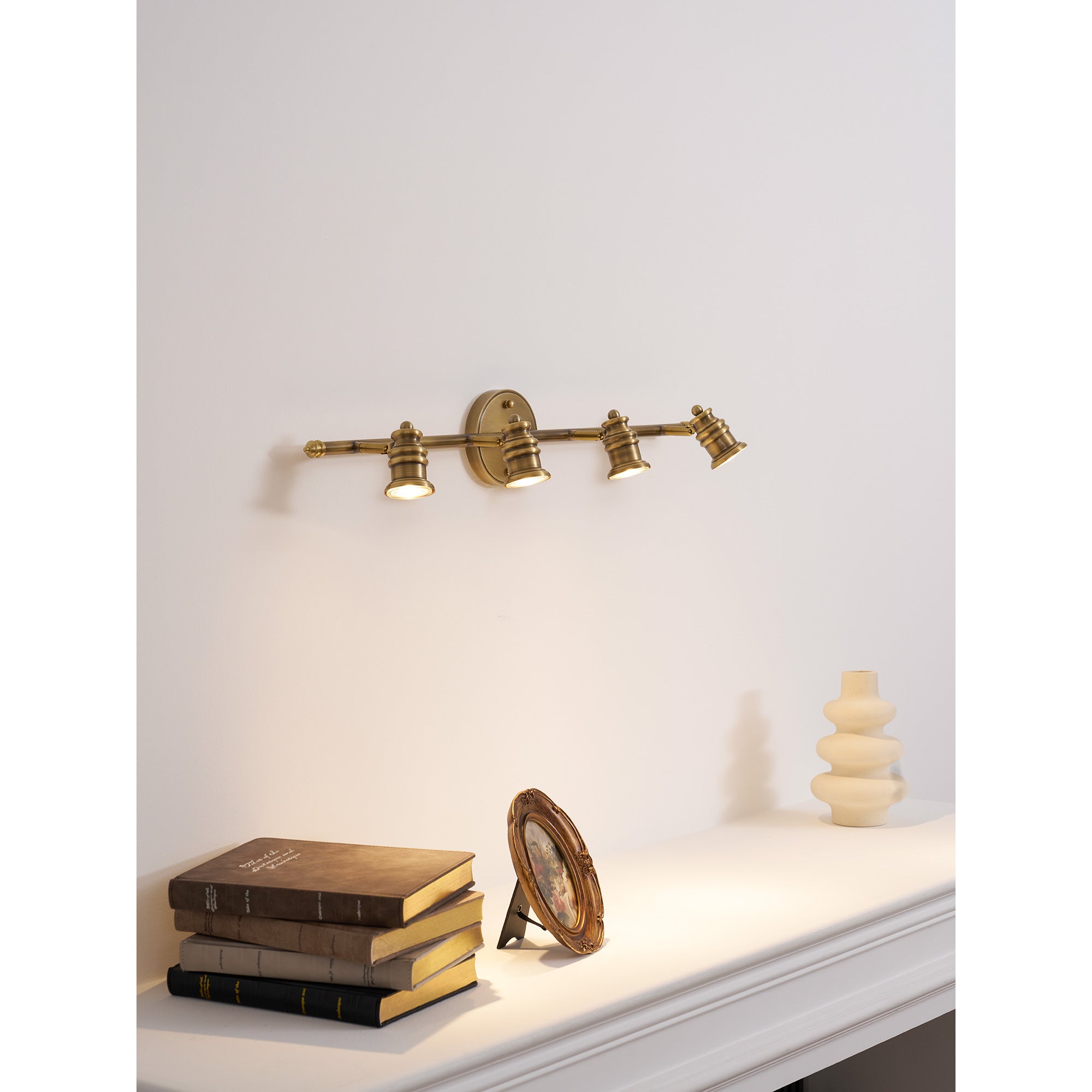 Three-head lamp against a textured wall.
