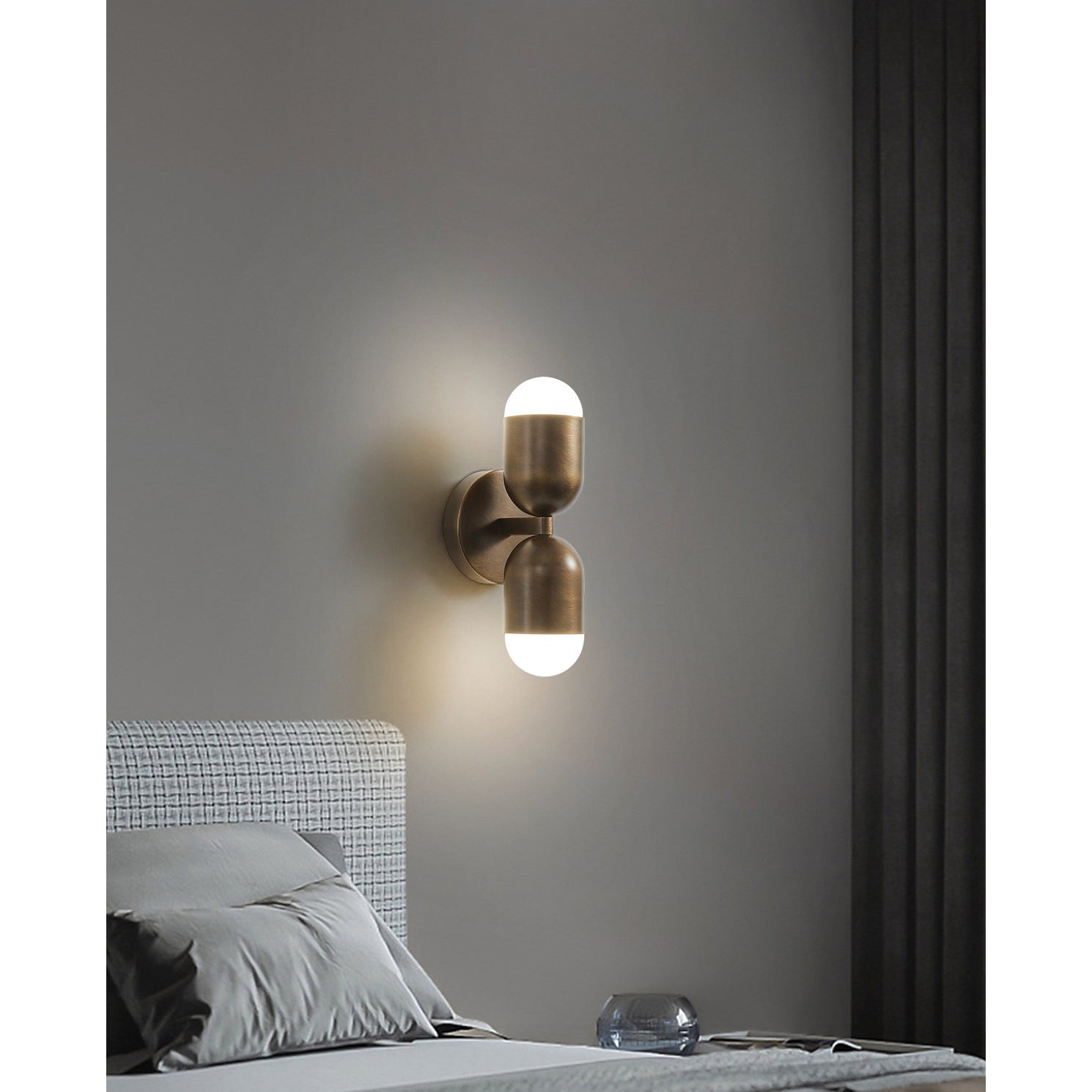 The Jensen Wall Sconce shown with a warm, glowing bulb.
