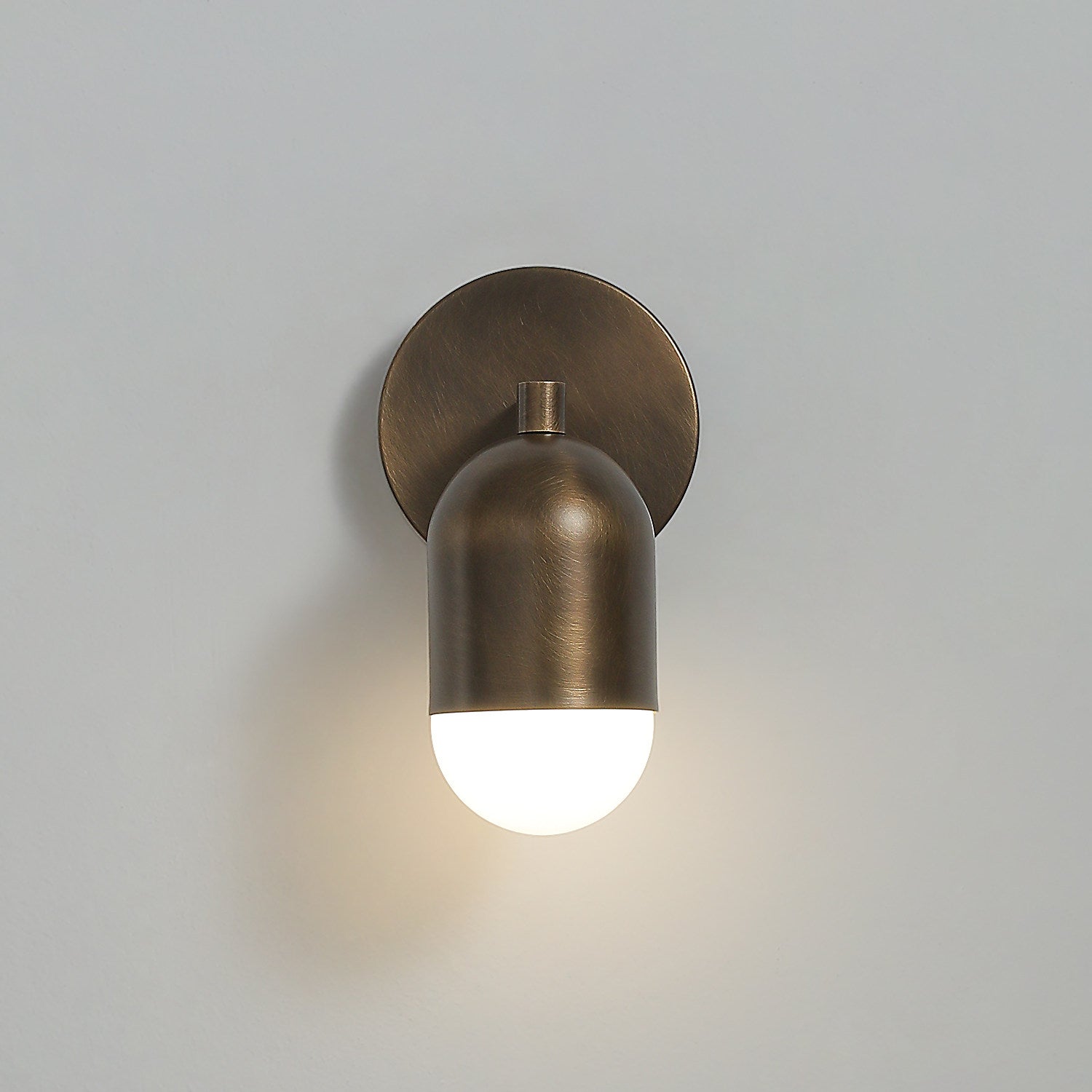 Downward glow from the bottom frosted glass shade of the Jensen Sconce.