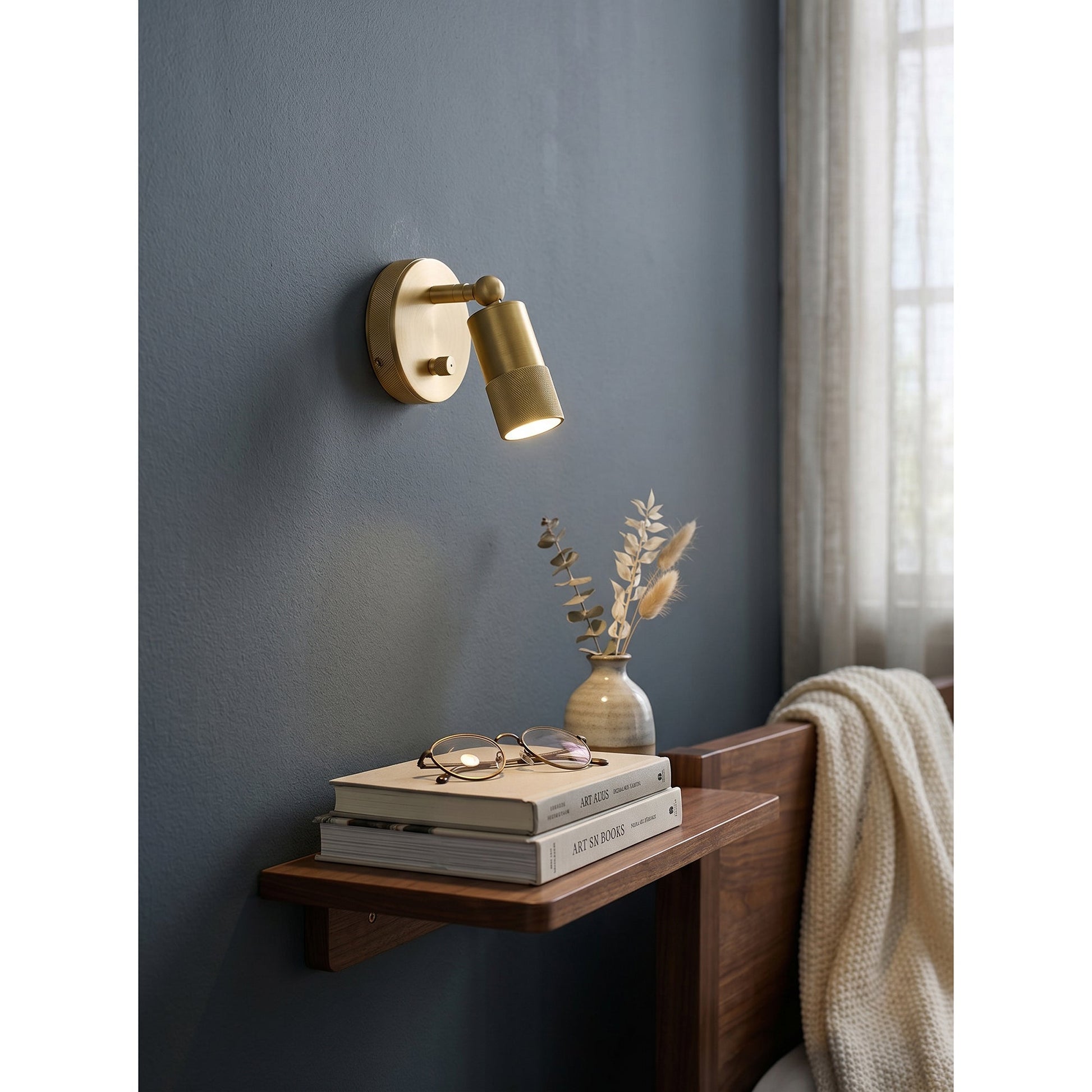 Jura Wall Sconce with its integrated dimmer switch visible.