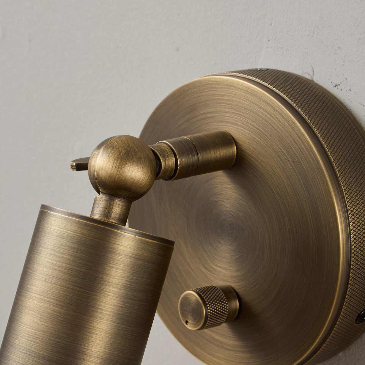 The industrial-style knurling on the sconce's body.