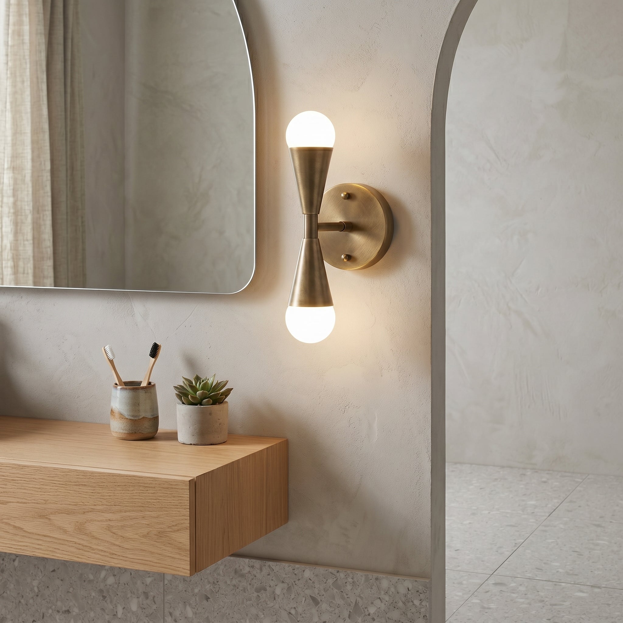 Close-up of the brass body and dual-cone design of the Karma Wall Sconce.
