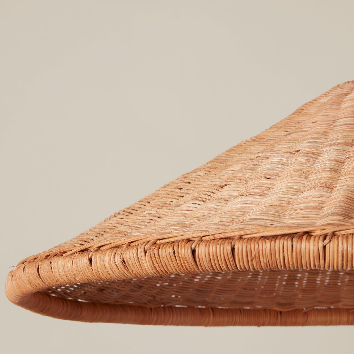 The Kasbah pendant lamp against a white wall to show its texture.