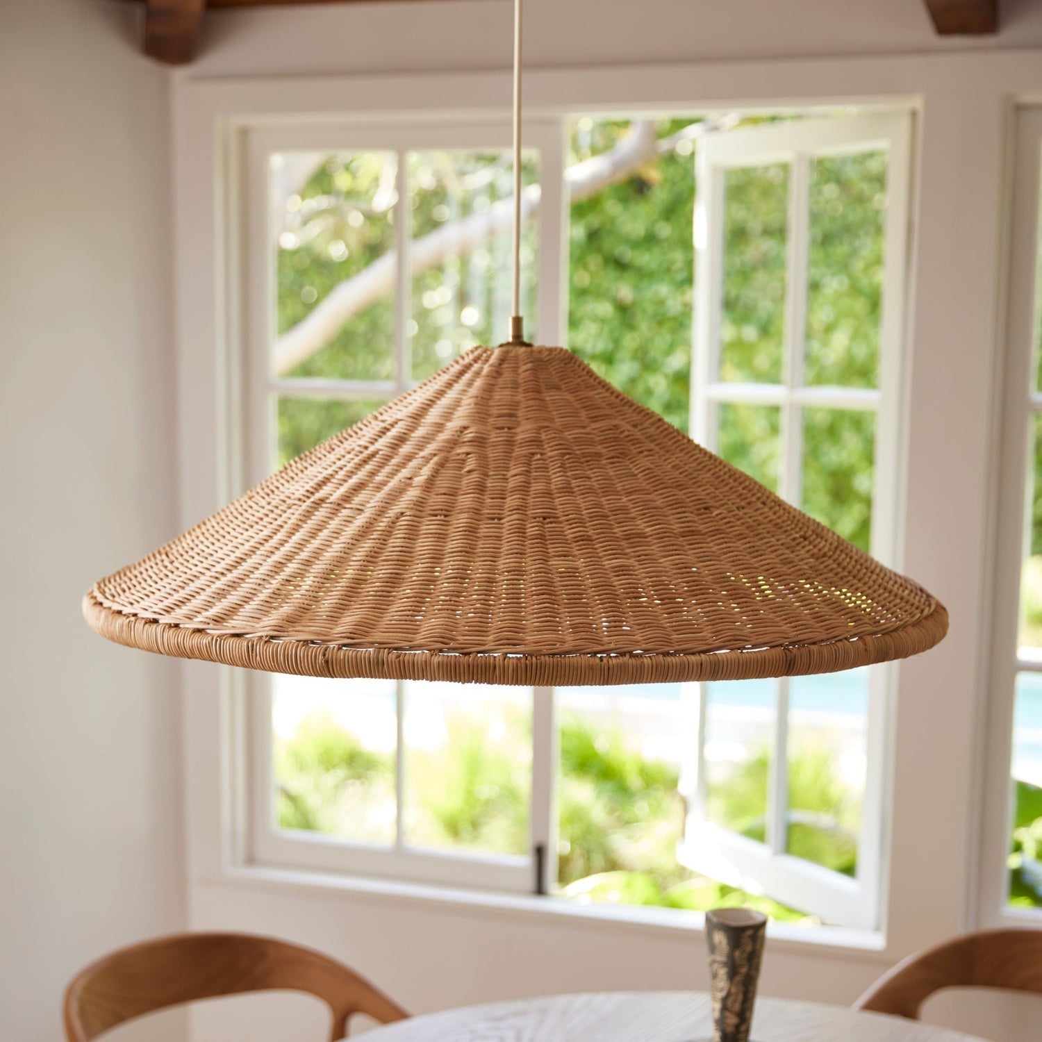 The large-sized rattan pendant lamp in a high-ceiling entryway.