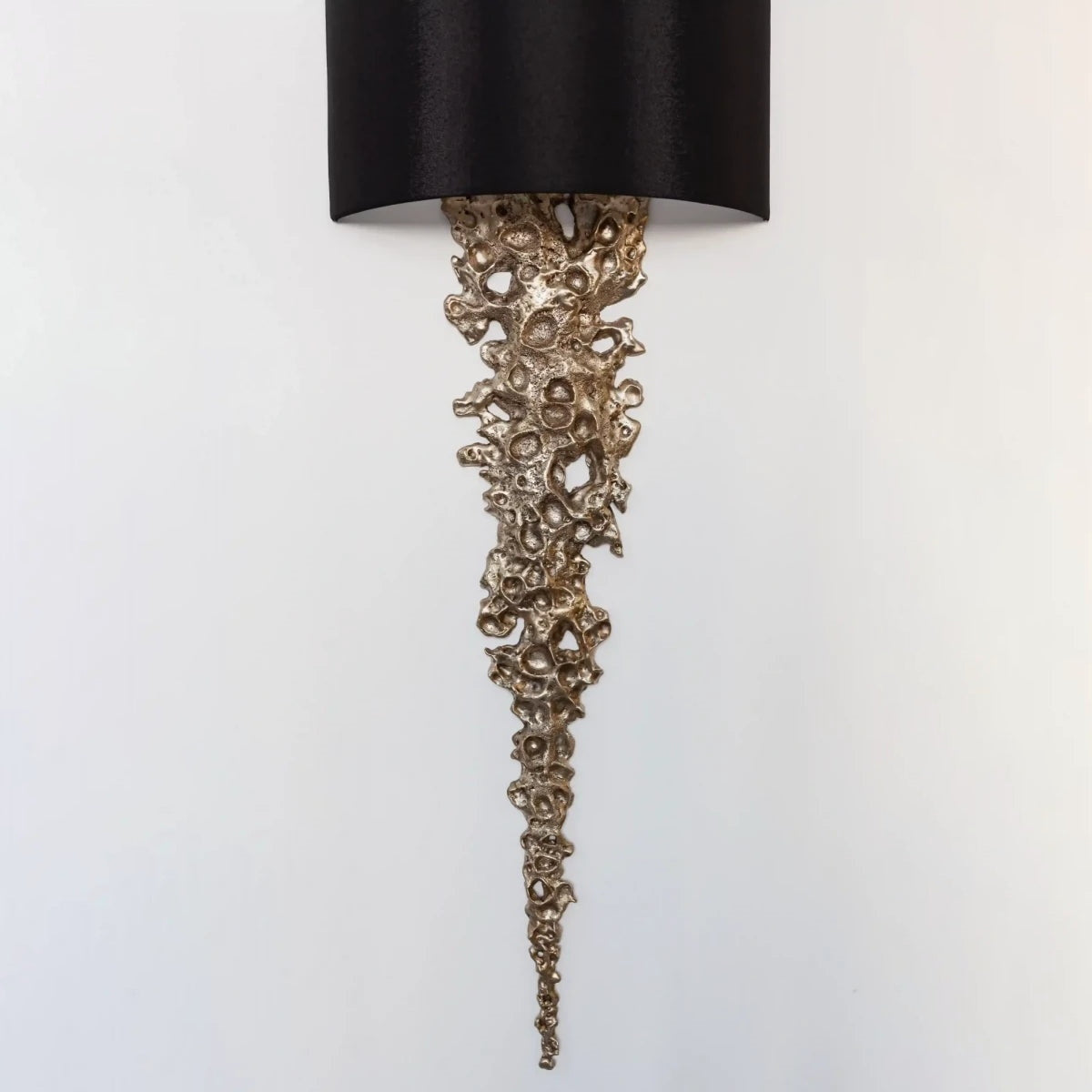 The Lava sconce adding ambiance to a moody powder room.