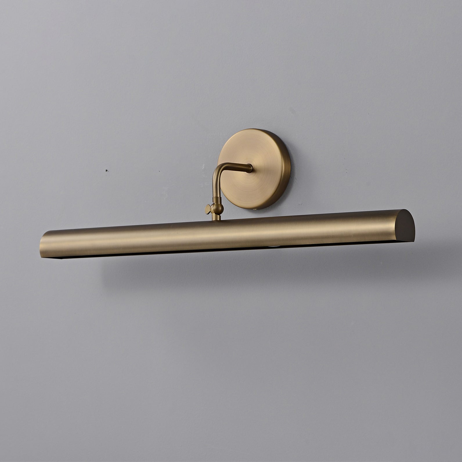 Close-up of the wall mounting plate in brushed brass.
