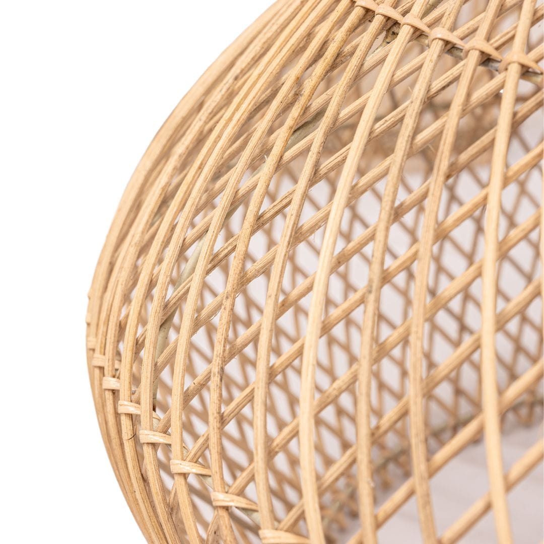 The black rattan shade contrasting with a light-colored wall.