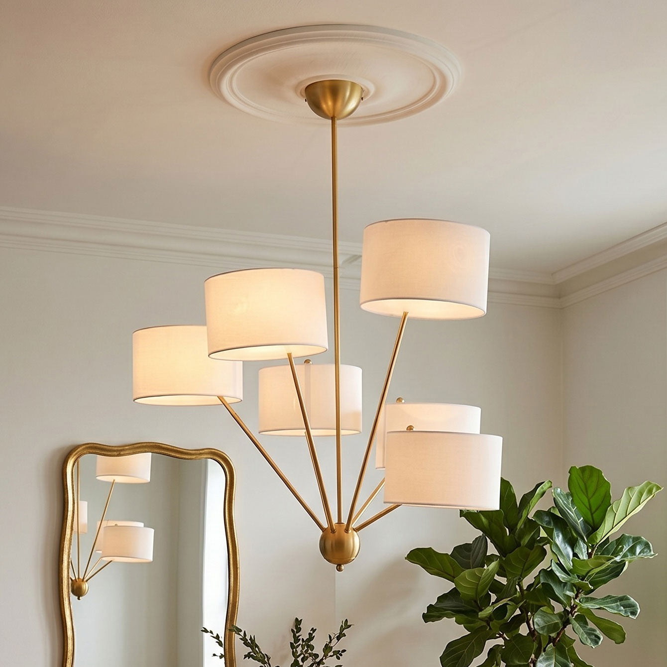 Close-up view of the central brass body and arms of the Mantis Chandelier.
