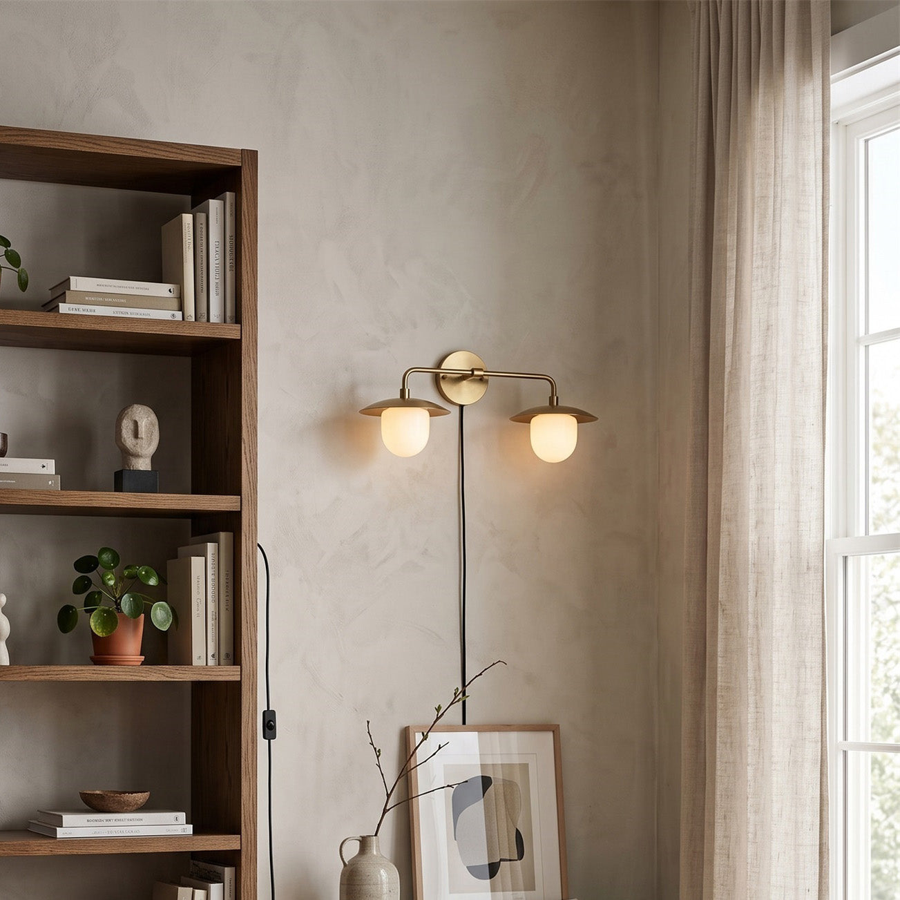 The 2-head version of the Marie wall sconce against a neutral wall.