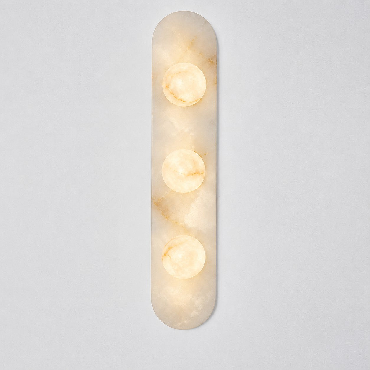 The Modulo Alabaster Wall Sconce as an accent light next to a piece of art.